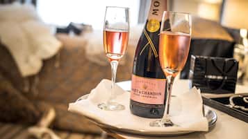 Una botella de champán Moët & Chandon y dos vasos de vino rosado sobre una bandeja.