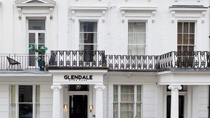 Un bâtiment blanc sur lequel on peut lire l’inscription suivante : « GLENDALE, N.Y. »