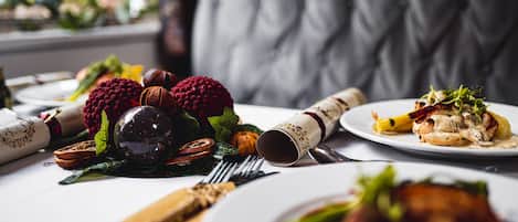 Uma mesa de jantar com diversos pratos, utensílios e um guardanapo dobrado.
