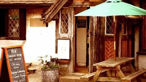 A rustic wooden building with a chalkboard sign advertising a new function room and doo seaters. - Chequers Inn Hotel (Forest Row)