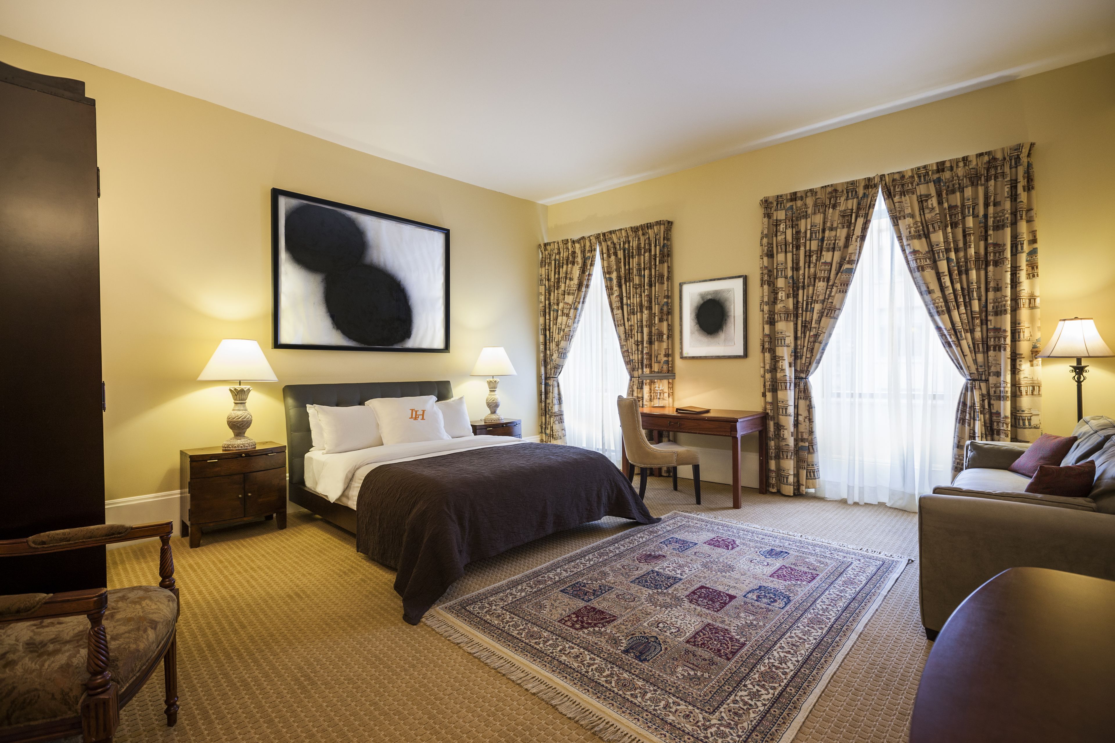 Ein Hotelzimmer mit einem Bett, Schreibtisch und zwei Stühlen.