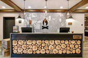 Una recepción con un mostrador de madera, un mural de mapa y un logotipo.