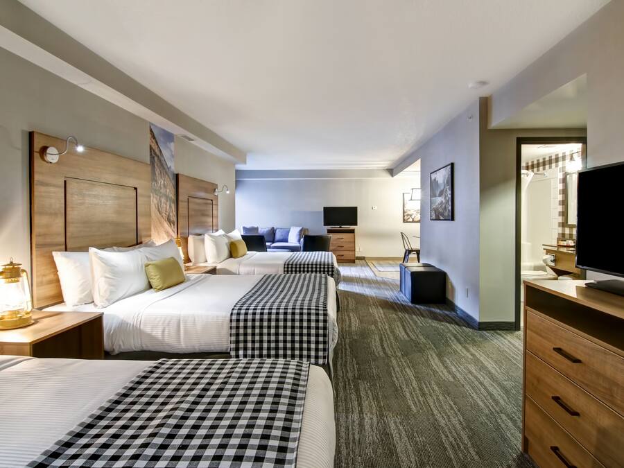 Hotellihuone, jossa on kaksi sänkyä, televisio, työpöytä ja vaatekaappi.