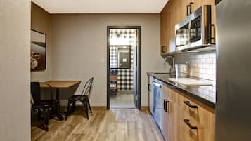 A modern kitchen with wooden cabinets, a stainless steel refrigerator, and a microwave.