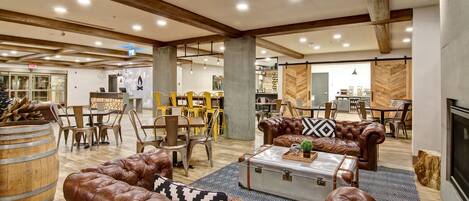 A spacious lounge area with leather sofas, a wooden coffee table, and a fireplace.