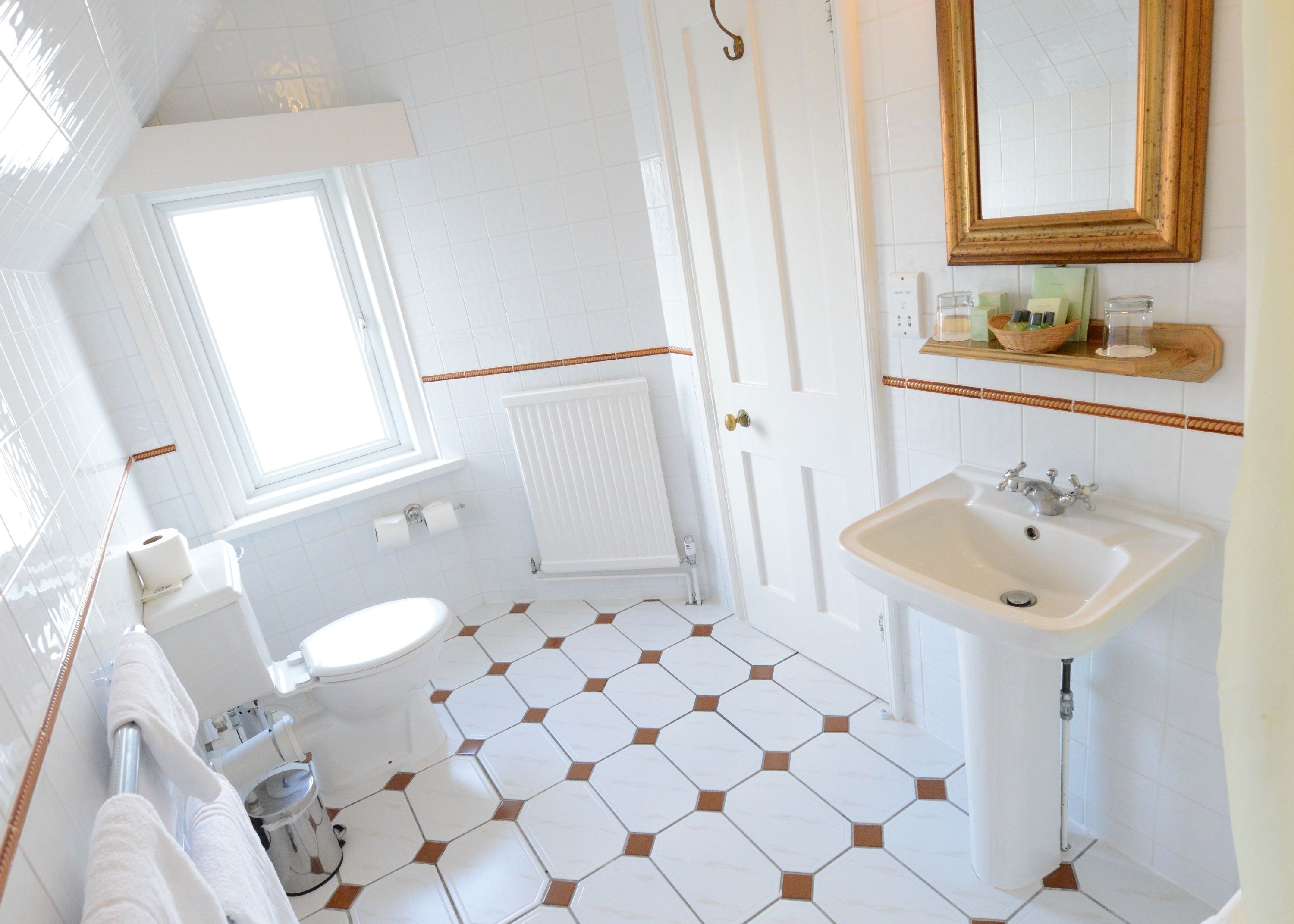 Une salle de bain avec des toilettes, un lavabo et une fenêtre.