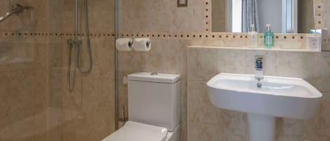 A bathroom with a toilet, a sink, and a shower.