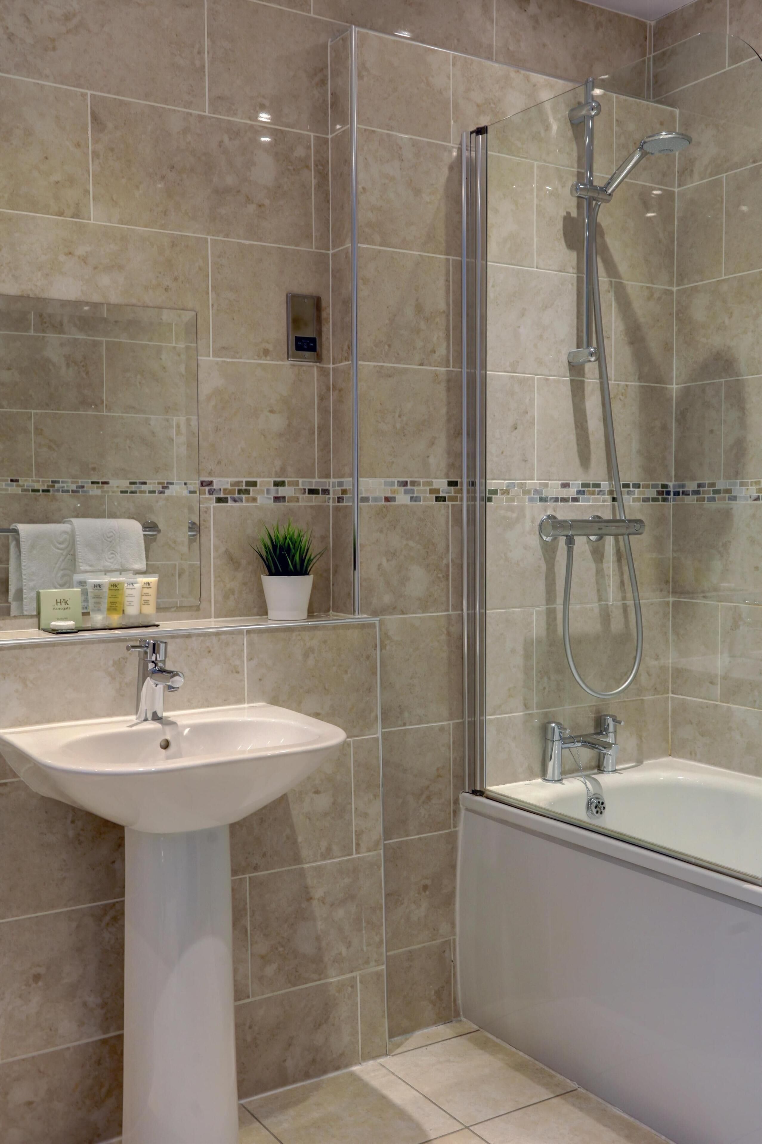 Un bagno moderno con lavandino, doccia vetrata e vasca da bagno.