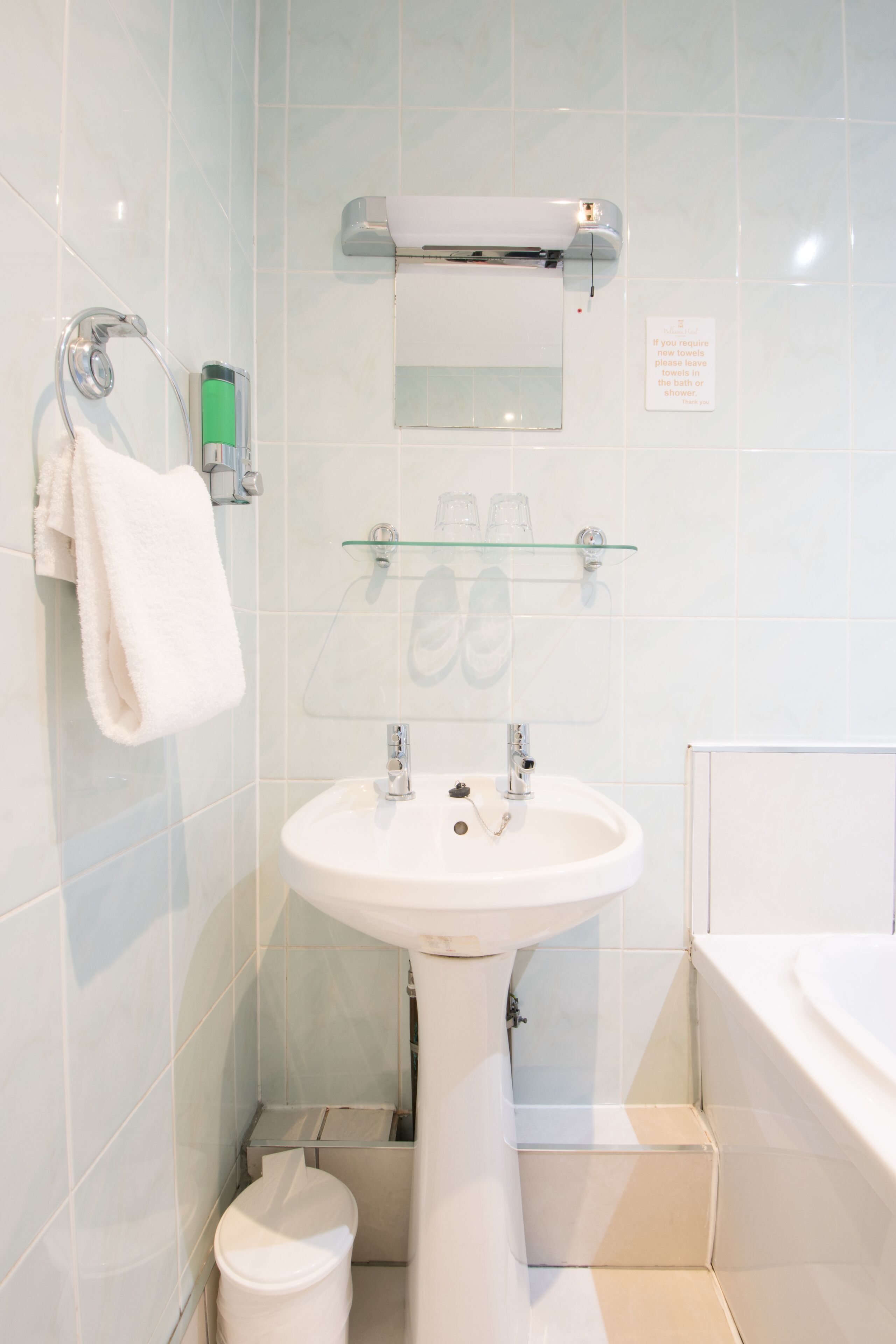 A modern bathroom with a white sink, glass shower enclosure, and a white bathtub.