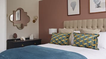 Un dormitorio ordenado con cama, mesitas de noche y decoración en la pared.
