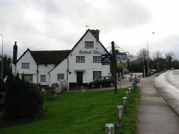 A white building with a sign reading "Roobuck Inn" and a smaller sign stating "BAR OPEN ALL DAY". - The Roebuck Inn (Stevenage)
