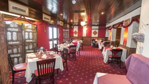 A restaurant with wooden paneling, red and white decor, and multiple tables and chairs. - The Roebuck Inn (Stevenage)