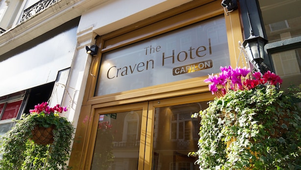 The Craven Hotel sign with a large entrance and hanging flower baskets. - The Craven Hotel (London)