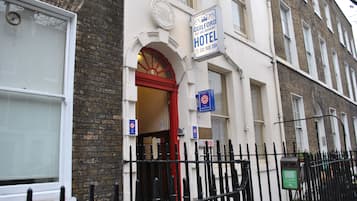 Traditional architecture meets warm hospitality at the Guilford Bed and Breakfast Hotel, featuring a charming entrance with a prominent archway.