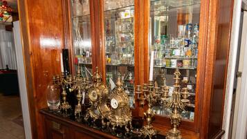 A wooden display cabinet with glass doors, containing various glassware and metal items.