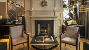 Una habitación acogedora con chimenea, dos sillones, una mesita de centro y una lámpara moderna.
