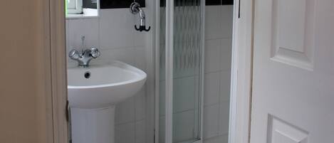 A bathroom with a white sink, a mirror, and a glass shower enclosure.