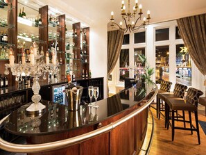 A bar area with a curved counter, wine glasses, bottles, and a decorative candelabra. - Mercure Darlington Kings Hotel (Darlington)