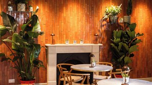 A cozy room with a brick wall, a fireplace, and wooden furniture. - Dukes Bath (Bath)