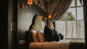 A bed with a headboard, pillows, and a window with curtains. - The Croft Hotel (Darlington)