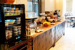 Ein reichhaltiges Frühstücksbuffet mit Speisen und ein Kühlschrank mit Getränken.