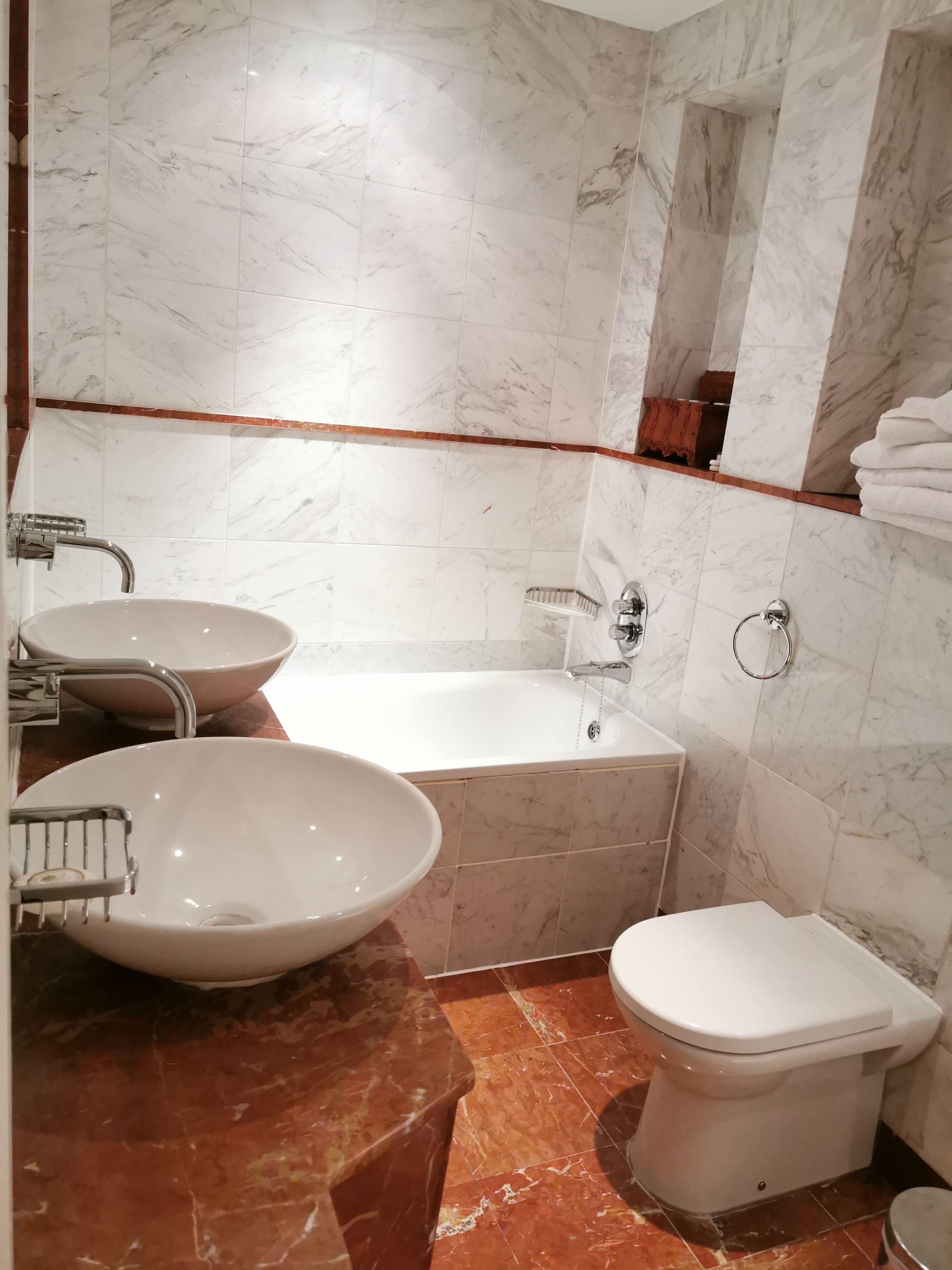 Un bagno con una vasca da bagno ampia, due lavandini e un water.