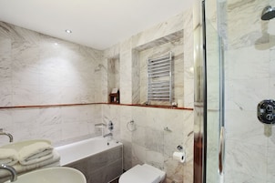 Un baño moderno con bañera, inodoro y cabina de ducha de vidrio.