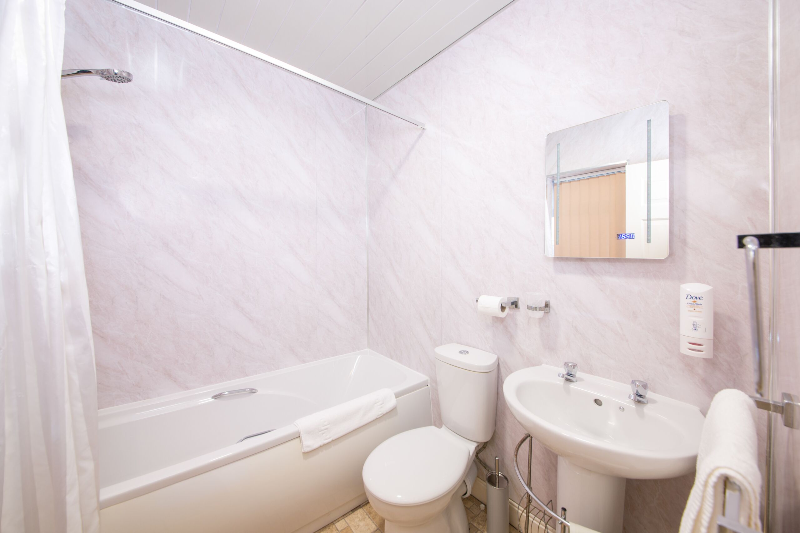 Une salle de bain avec une baignoire, des toilettes, un lavabo et un miroir.