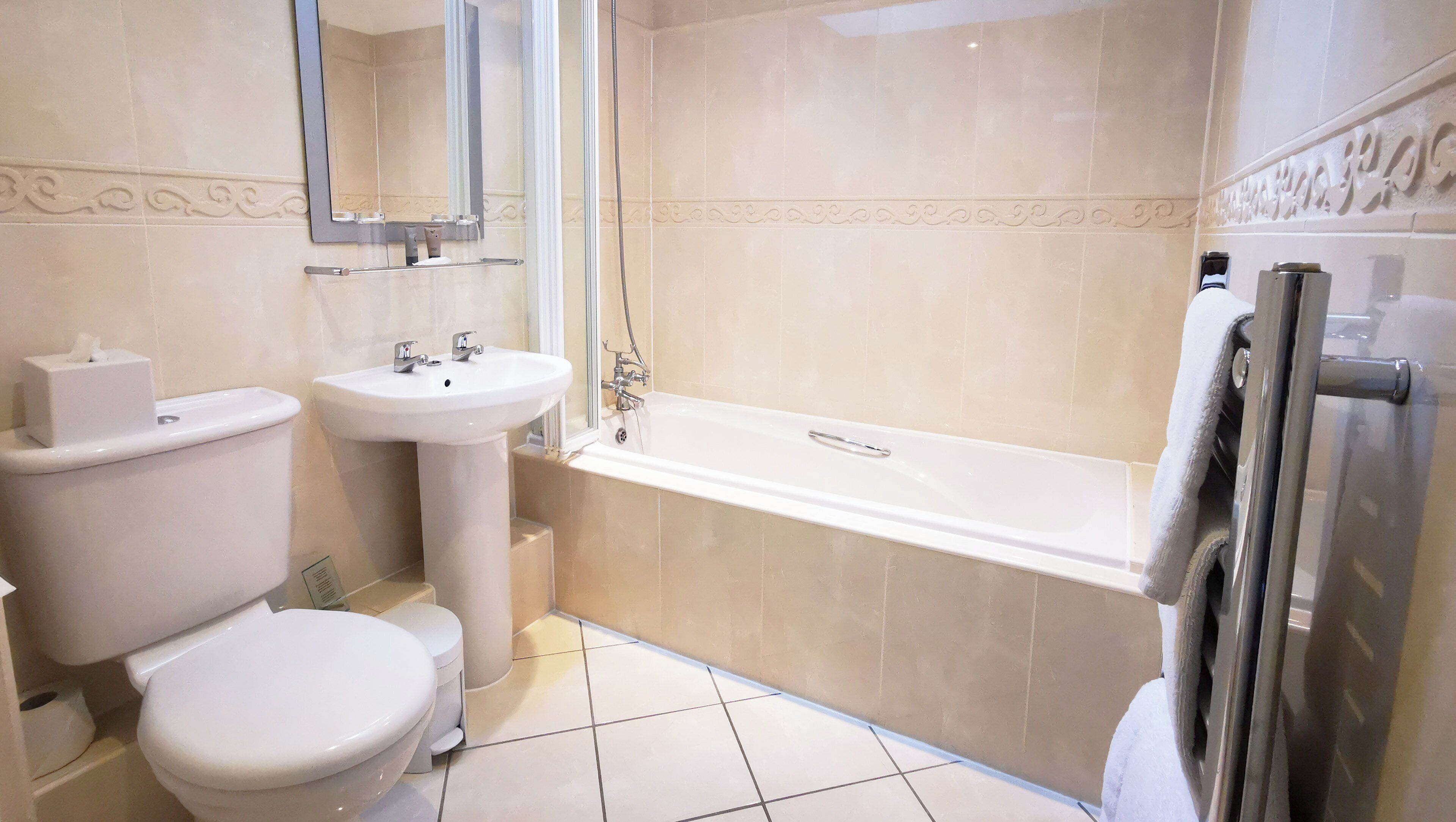A bathroom with a toilet, sink, and bathtub.