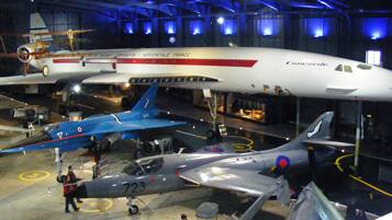 A museum with various aircraft on display, including a Concorde and a fighter jet.