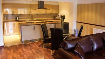 A modern kitchen with a dining area, including a sofa and a coffee table.