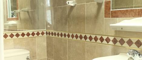 Une salle de bain avec des toilettes, un lavabo et un miroir.
