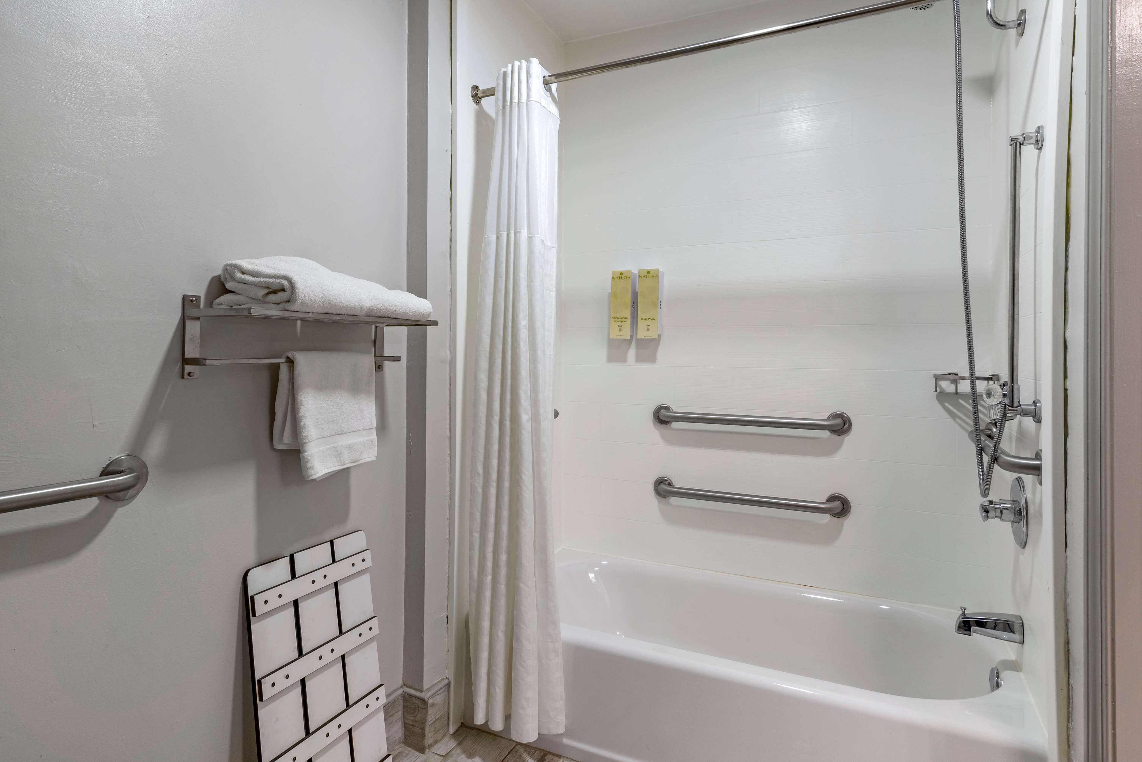 Une salle de bain équipée d’une baignoire, d’une douche, d’un porte-serviettes et d’un sèche-mains.