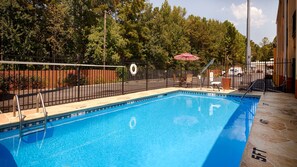 Una piscina al aire libre, tumbonas
