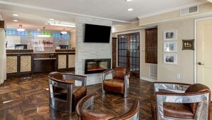 A modern lobby with leather armchairs, a fireplace, a flat-screen TV, and a reception desk. - Best Western Allatoona Inn & Suites (Cartersville)