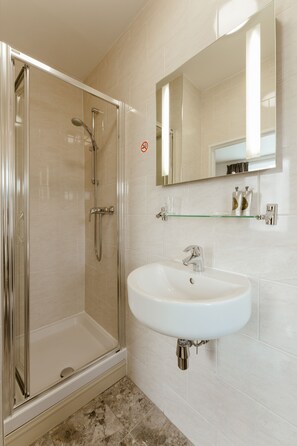 Tweepersoonskamer | Badkamer | Een douche, een haardroger, handdoeken
