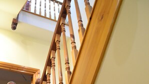 A wooden staircase with a handrail and a landing area. - Hotel 65 (London)