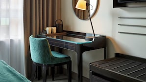 Une chambre d’hôtel équipée d’un bureau, d’une chaise, d’une télévision et d’un lit.