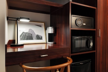 A room with a sofa, a lamp, a window with blinds, and a staircase. at The Bayard