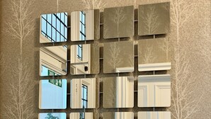 A wall with multiple square mirrors arranged in a grid pattern. - Northumberland Hotel (Edinburgh)