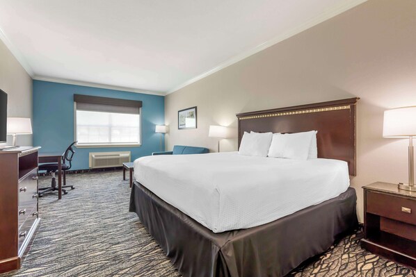 A hotel room with a large bed, a desk, a chair, and a window with blinds. - Best Western Plus Lake Worth Inn & Suites (Fort Worth)