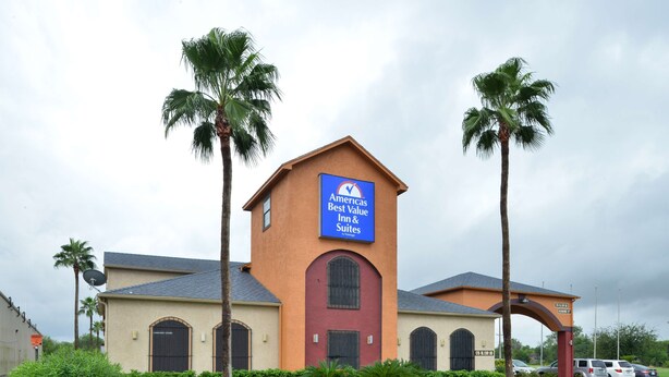A building with a sign for "Americas Best Value Inn & Suites" featuring a red door and arched windows. - Americas Best Value Inn & Suites San Benito (San Benito)
