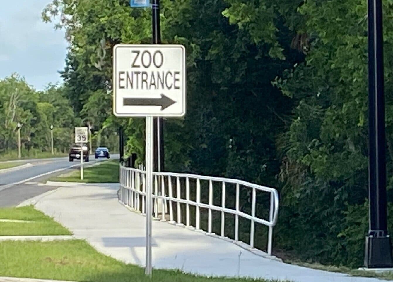 Señal que indica la entrada del zoológico con una flecha direccional.