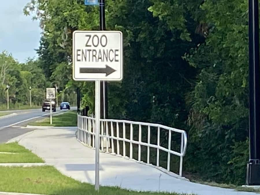 Señal que indica la entrada del zoológico con una flecha direccional.
