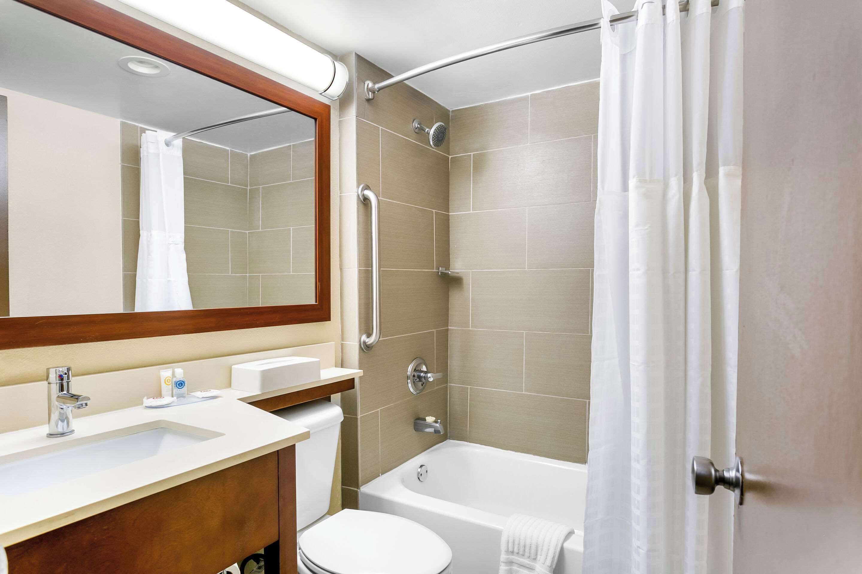 A modern bathroom with a sink, toilet, and bathtub.