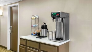 Habitación de hotel con kitchenette que incluye cafetera, hervidor de agua y refrigerador pequeño.