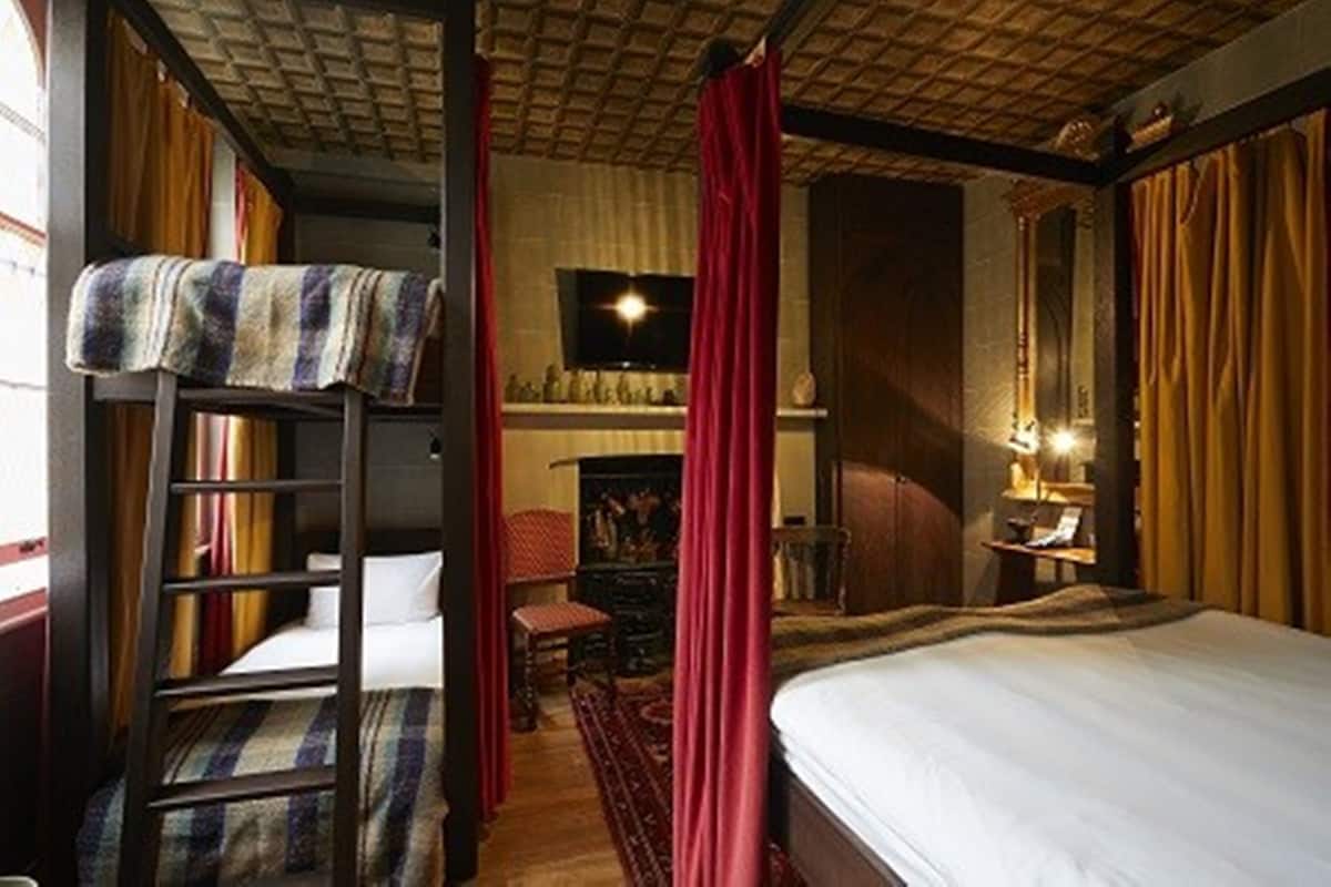 A room with a bunk bed, a fireplace, and a television.