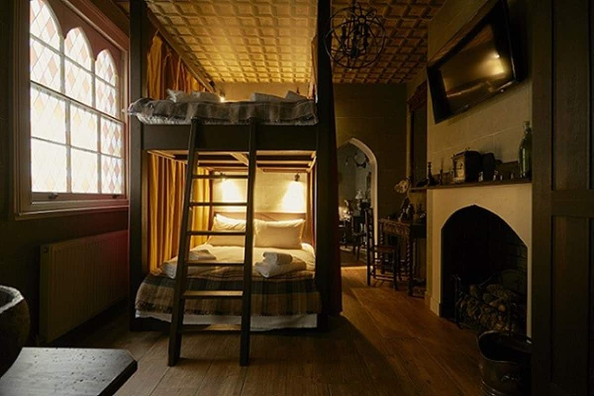 A cozy room with a bunk bed, a fireplace, and a television.