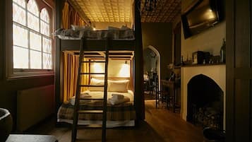 Una habitación acogedora con literas, chimenea y televisión.