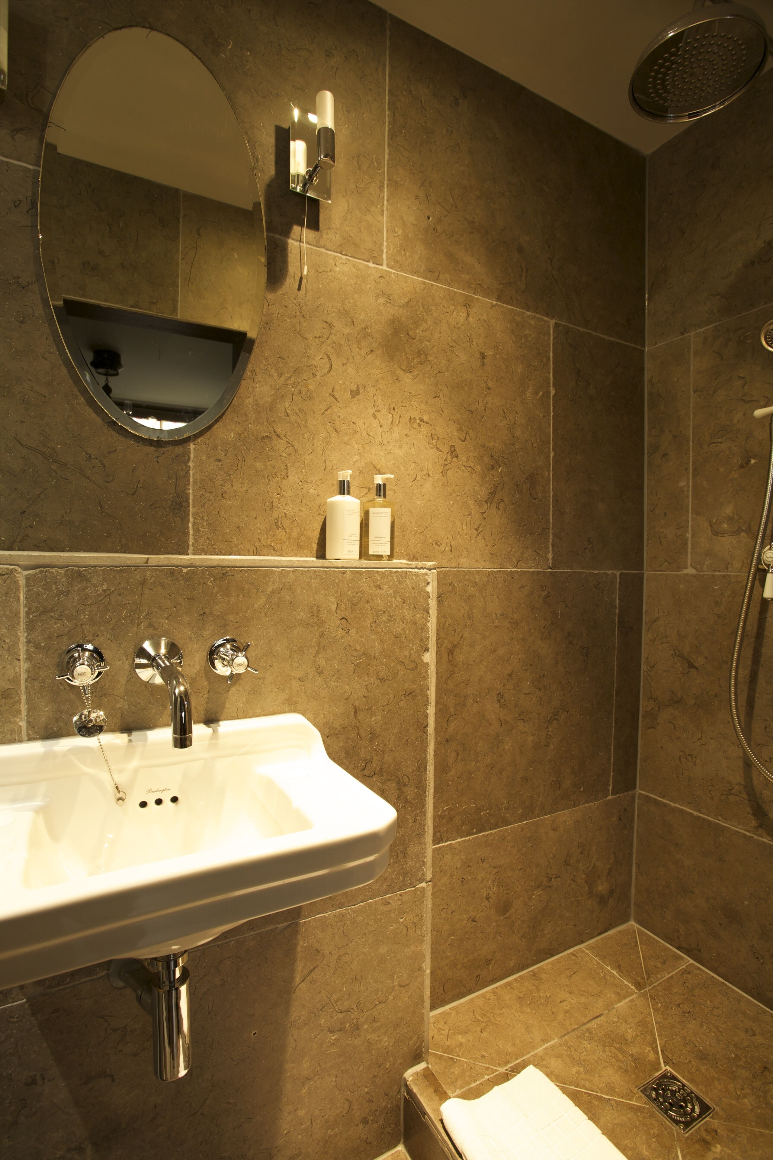 Un baño con lavamanos, espejo y ducha.